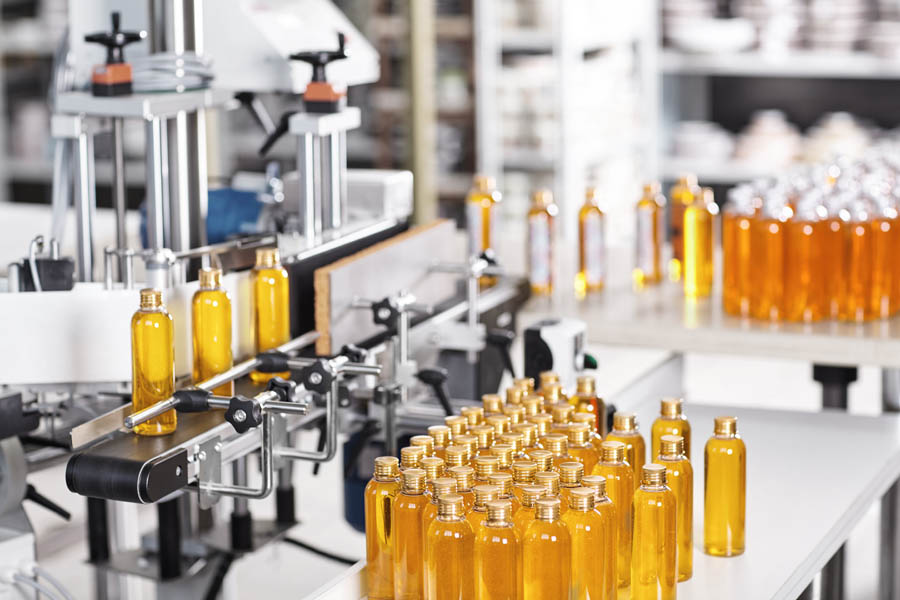 Bottles filled with yellow thick substance standing on desk and